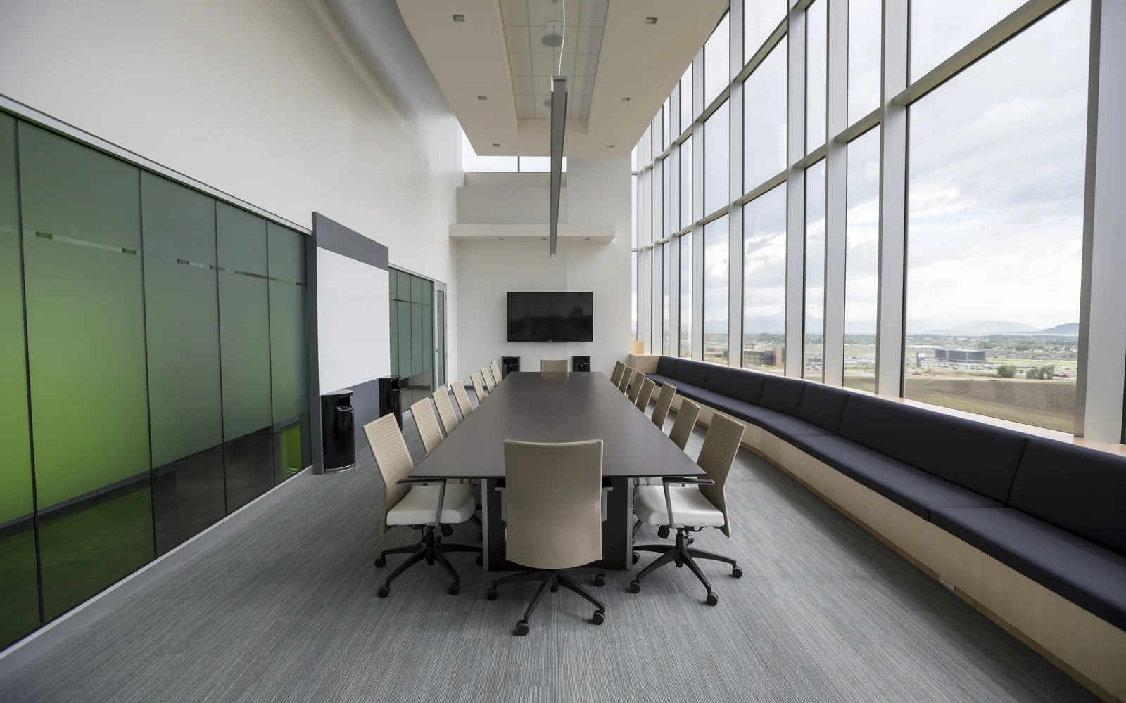 Modern boardroom with green glass wall and natural light